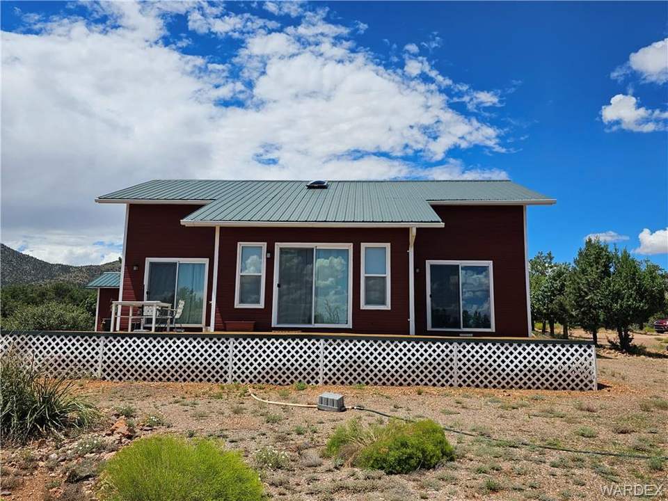 2 bed, 1 bath home on 40.96 acres in Kingman: Back of house featuring a metal roof and a wooden