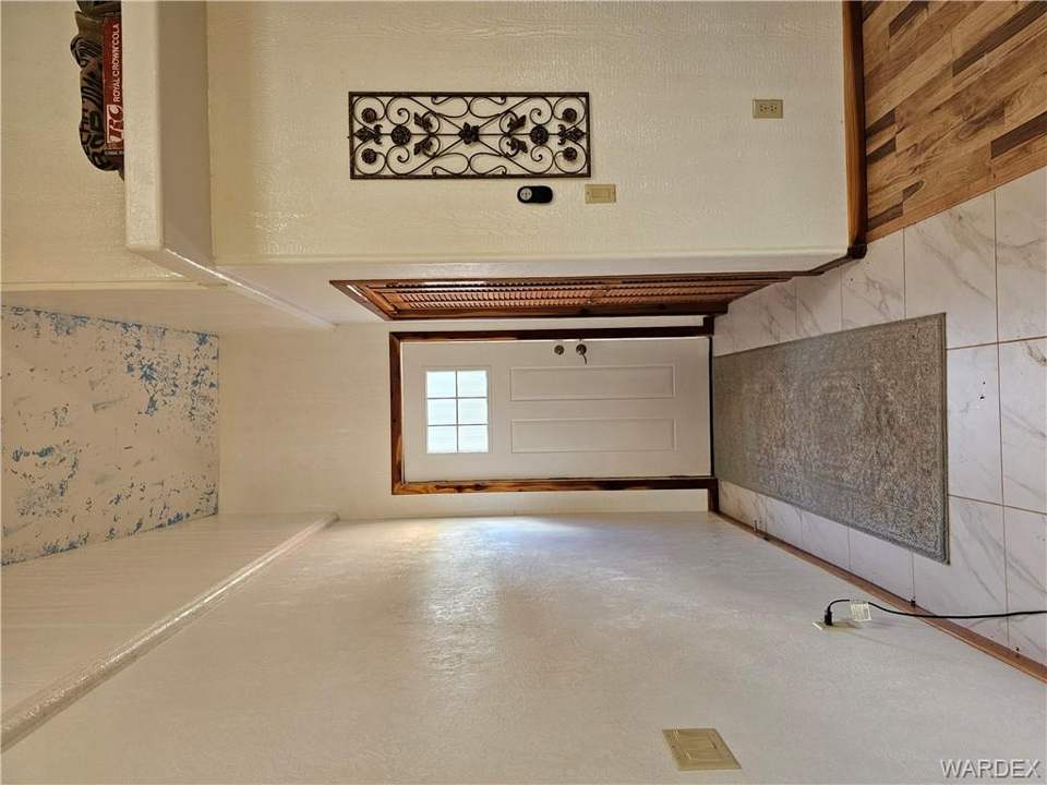 2 bed, 1 bath home on 40.96 acres in Kingman: Doorway to outside with marble look tiles, a tower