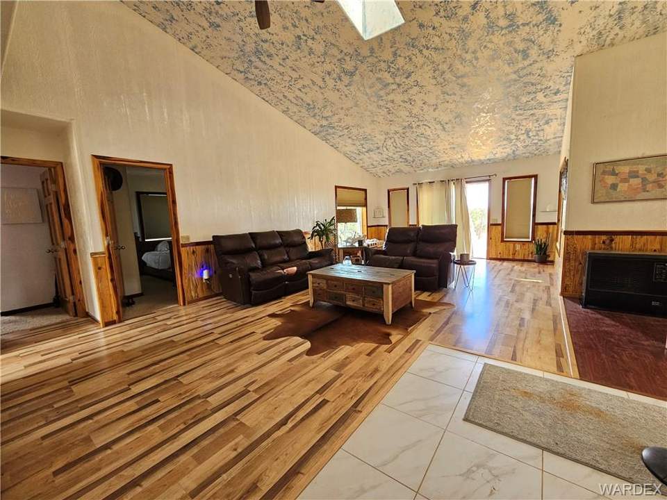 2 bed, 1 bath home on 40.96 acres in Kingman: Living room featuring wainscoting, wooden walls, l