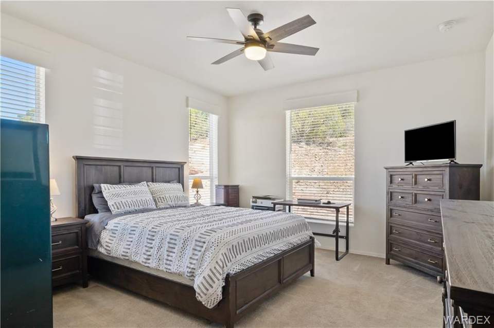 3 bed, 2 bath home in Kingman in Kingman: Bedroom with light colored carpet and a ceiling fa