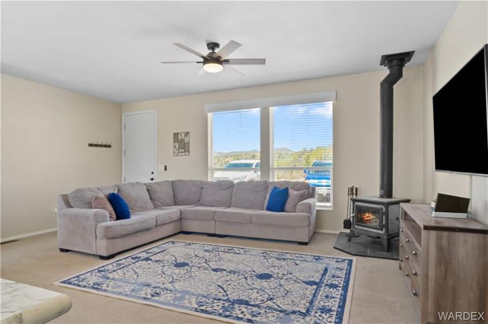 3 bed, 2 bath home in Kingman in Kingman: Living room with a wood stove, light colored carpe