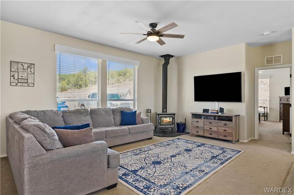3 bed, 2 bath home in Kingman in Kingman: Living room with a wood stove, a ceiling fan, and